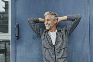 Portrait of laughing mature man in front of gym photo