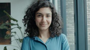 Woman lifts head and starts smiling into camera lens photo